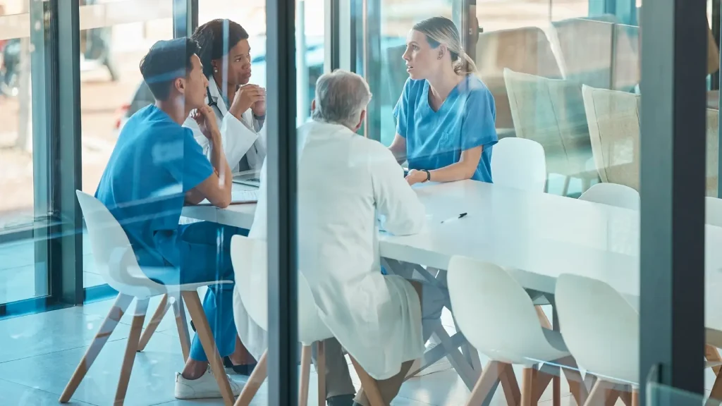 Group of medical professionals sitting at table discussing