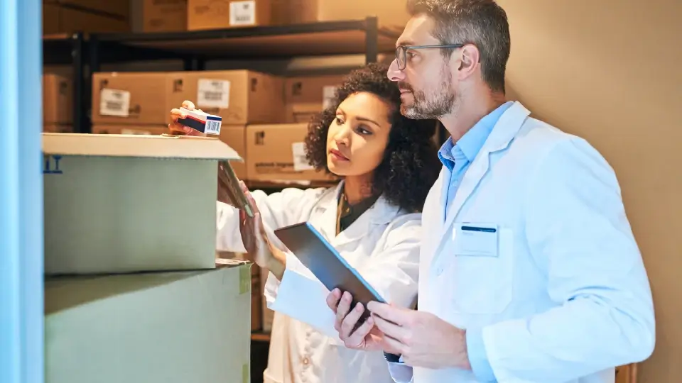 Man and woman scientists check inventory of a shipment of clinical trial equipment from Axelerist